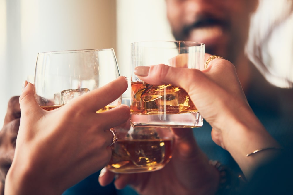 Emberek alkoholos italokkal koccintanak egy bulin.